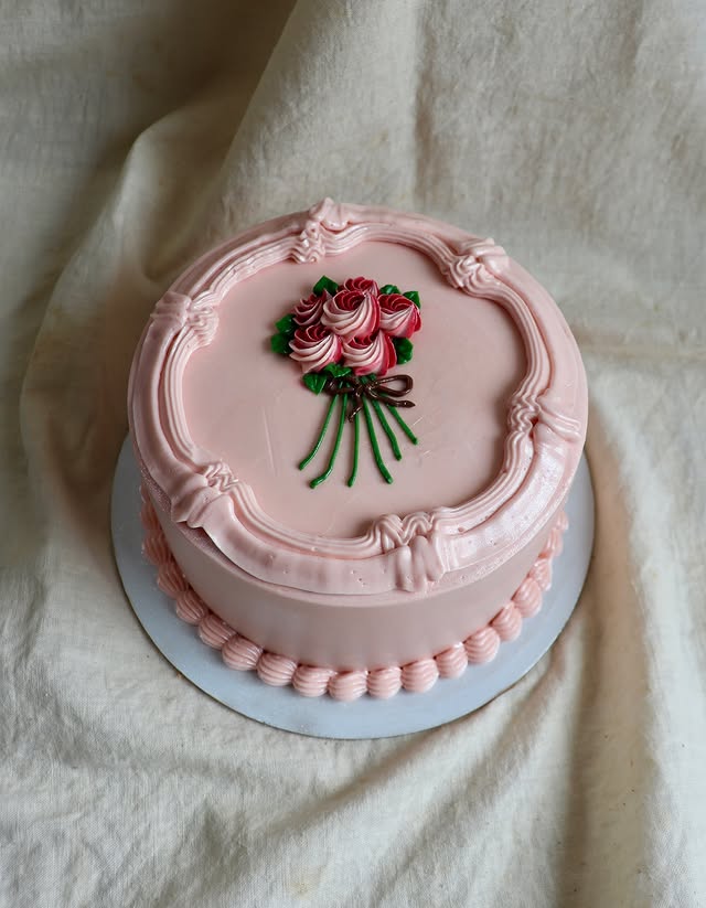 Claro Bakehouse cake with hand-piped rose bouquet in an ornate frame design