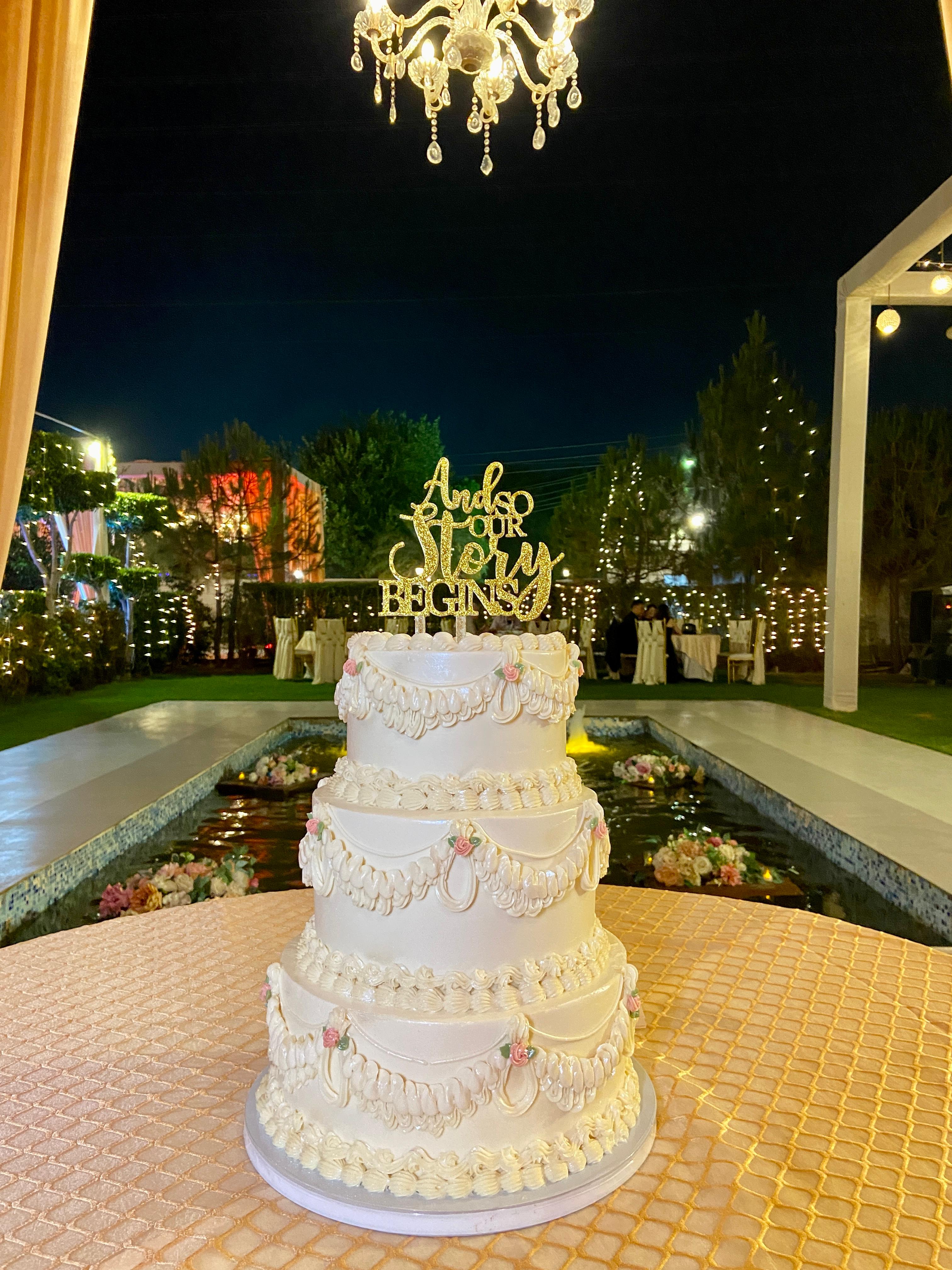 Claro Bakehouse three-tier wedding cake styled at an evening reception venue